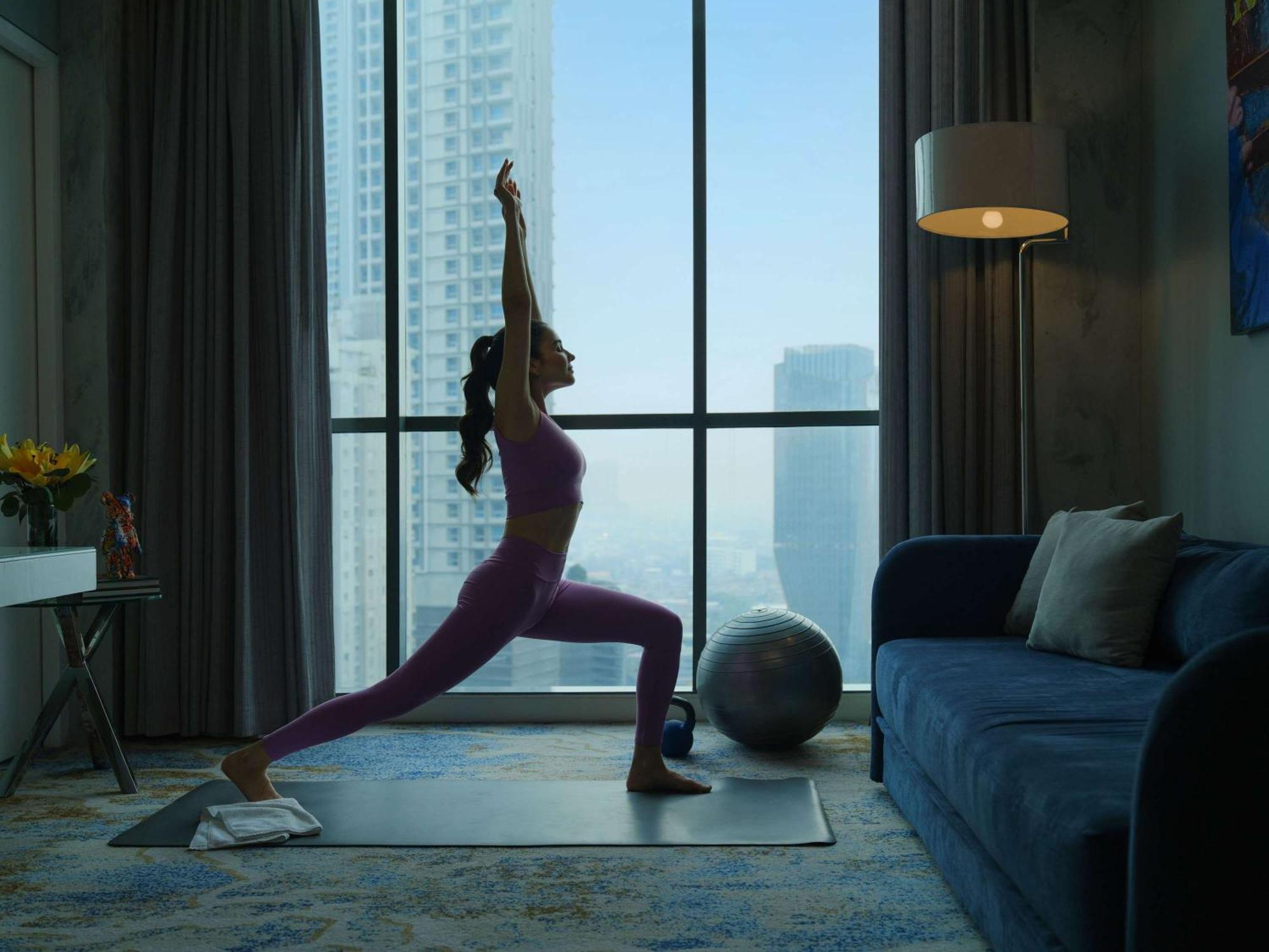 Pullman Jakarta Central Park Экстерьер фото A woman practicing yoga at home